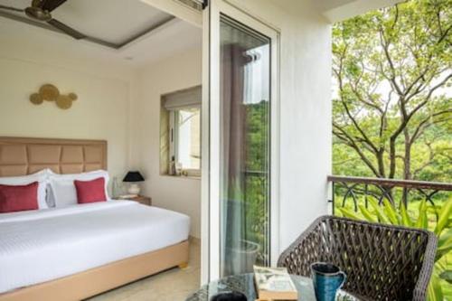 een slaapkamer met een bed en een balkon bij Luxurious Apartment with a Pool near Candolim 11 in Goa
