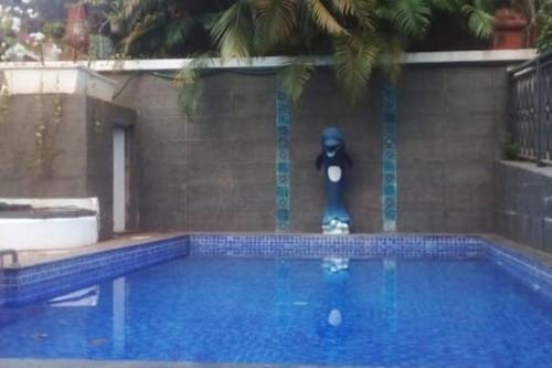 een standbeeld van een persoon die naast een zwembad staat bij Luxurious Apartment with a Pool near Candolim 11 in Goa