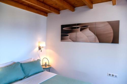 a bedroom with a picture of vases on the wall at Punda Beach Seaside Retreat in Logaras