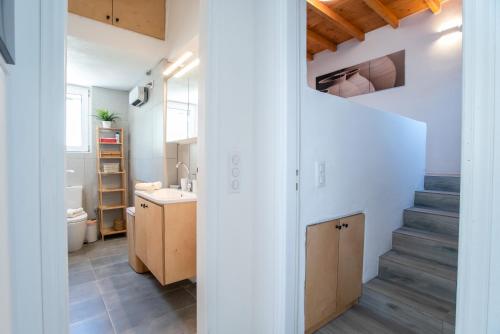a bathroom with a sink and a staircase in a room at Punda Beach Seaside Retreat in Logaras