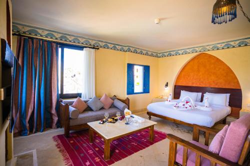 a hotel room with a bed and a living room at Marina Lodge at Port Ghalib in Port Ghalib