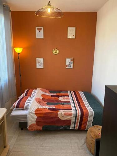une chambre avec un lit avec un mur orange dans l'établissement Studio cosy avec jardin Chatou, à Chatou