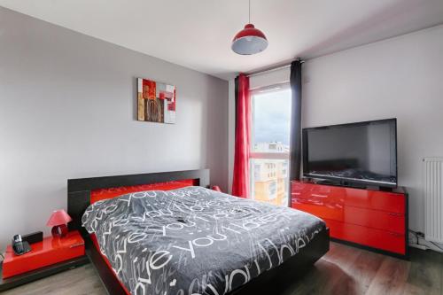 a bedroom with a bed and a flat screen tv at Résidor - Lumineux Duplex à saint Ouen in Saint-Ouen