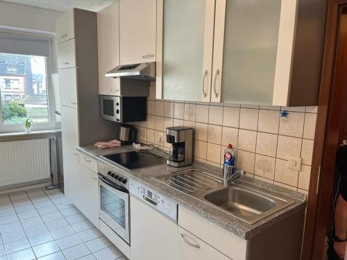 een keuken met een wastafel en een aanrecht bij Gästewohnung 1 OGR in der Nähe zur Veltinsarena - Gästewilli 1 in Gelsenkirchen