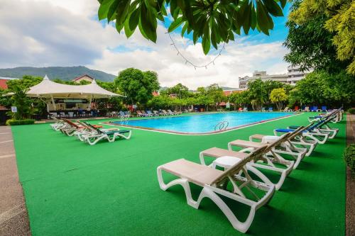 a row of lounge chairs next to a swimming pool at Patong Resort Hotel - SHA Extra Plus in Patong Beach