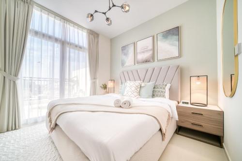 ein weißes Schlafzimmer mit einem großen Bett und einem Fenster in der Unterkunft Autumn Serenity Manor: Luxury 3 Bedroom Townhouse in Dubai