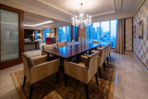 Ritz Carlton DIFC Downtown Dubai في دبي: غرفة طعام مع طاولة وكراسي طويلة