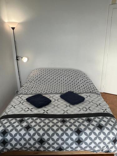 łóżko z czarnymi poduszkami w pokoju w obiekcie Vivez le Bonheur - Plage - Port de plaisance - Vue mer w Hawrze