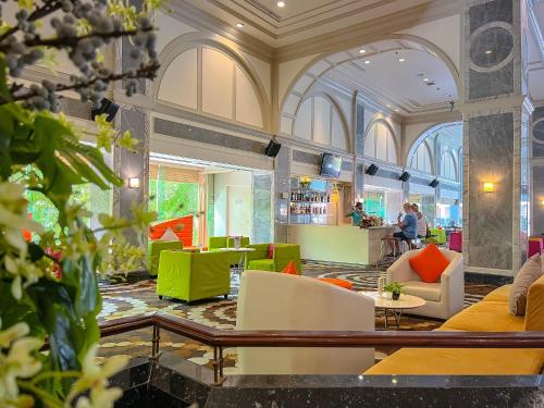 a lobby with green and orange chairs and tables at Patong Resort Hotel - SHA Extra Plus in Patong Beach