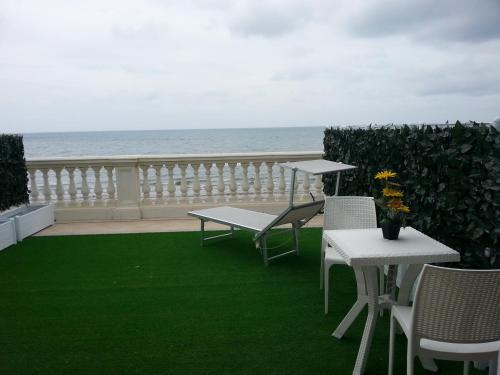 une terrasse avec une table et des chaises et l'océan dans l'établissement Il Lido, à Giannella