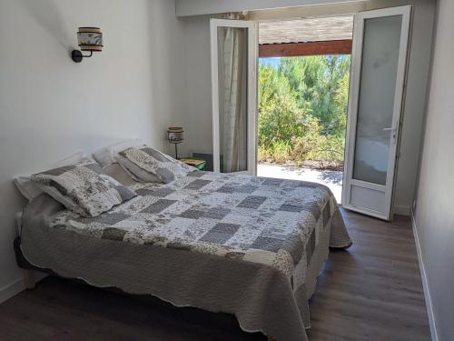 1 dormitorio con 1 cama y puerta corredera de cristal en Provençal house between sea and vineyards, en Le Beausset