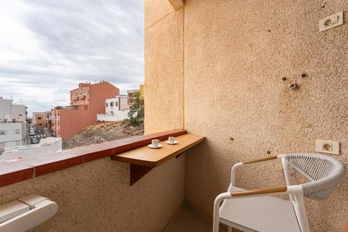 a balcony with a white chair and a window at Apartamento Bellavista, bajo Alcalá in Guía de Isora