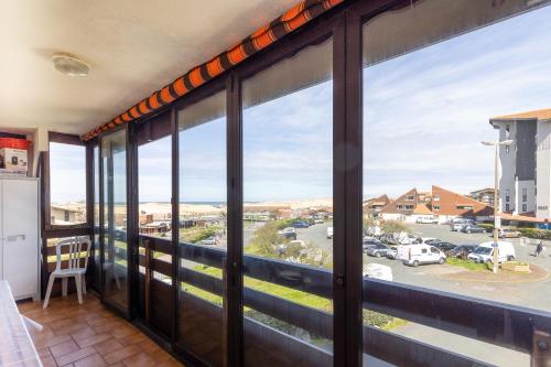 a room with large windows with a view of a street at Location Noly in Seignosse