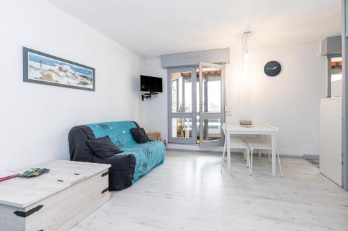 a living room with a couch and a table at Location Noly in Seignosse