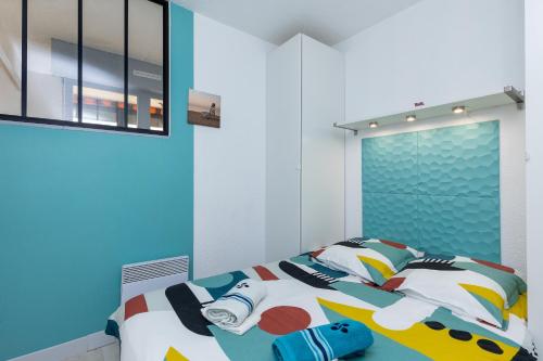 Location Noly في سانيوس: غرفة نوم مع سرير مع وسائد ملونة