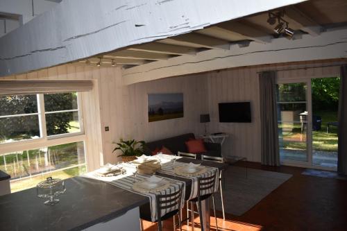 un salon avec une table avec des chaises et un canapé dans l'établissement Hautes Pyrénées Les Roses dAdour, à Moulédous