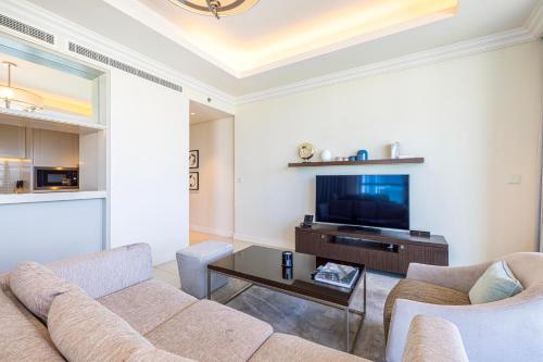 a living room with a couch and a tv at The Address Fountain Views - Residence 2 Bedroom with Burj Khalifa view in Dubai