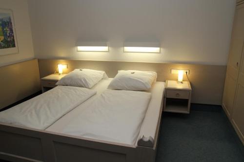 a bedroom with two beds and two lights on two tables at Hotel und Gasthof Zur Laute in Mindelheim