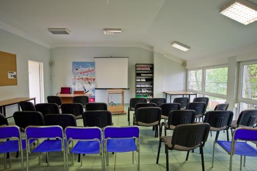 a classroom with blue chairs and a white board at Yacht Club Residence Sopot in Sopot