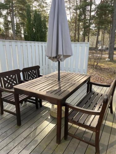 een houten tafel met een paraplu op een terras bij Hangon helmi pariskunnalle tai yksin matkustavalle in Hanko