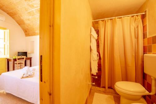 ein Bad mit einem Bett und einem WC in einem Zimmer in der Unterkunft Palazzo Le Zicaredde in Salve