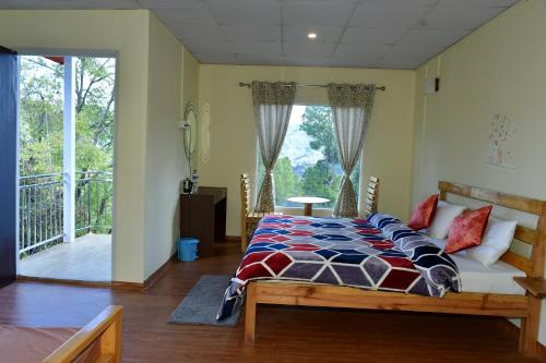a bedroom with a bed and a balcony at Kumaon Roadies Adventure Camp & Resort in Mukteshwar