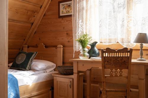 a bedroom with a bed and a desk and a window at Sweet Home Sweet APARTZAKOP in Kościelisko