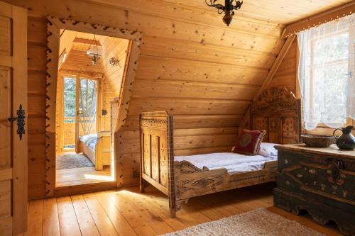 a log cabin bedroom with a bed in the corner at Sweet Home Sweet APARTZAKOP in Kościelisko