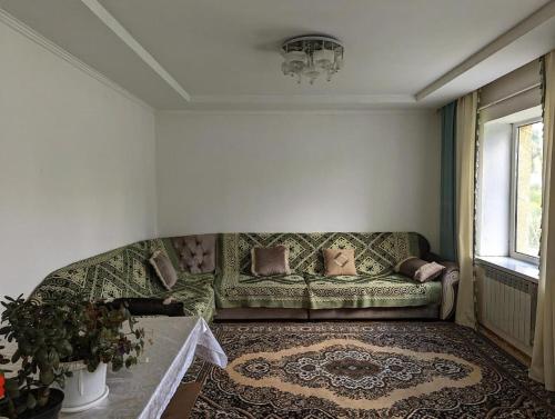 sala de estar con sofá y mesa en Tabyldy Guest Houst, en Kasymbek