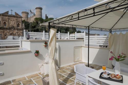 balcón con mesa, sillas y sombrilla en Siramà Suite Deluxe, en Oria