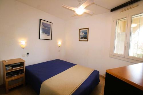 une chambre avec un lit, un bureau et une fenêtre dans l'établissement Gasdu - Golfe de St-Tropez- Appartement avec accès mer, à Gassin