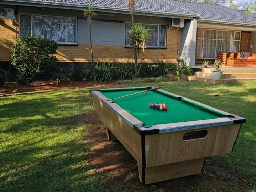 a pool table in a yard in front of a house at Grand Diamond Lodge in Roodepoort