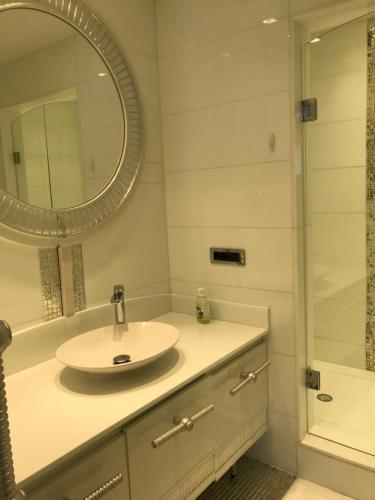 伊斯坦堡的住宿－Kiralık Daire - Ritz Carlton Residance Süzer Plaza'da Eşyalı Manzaralı，一间带水槽和镜子的浴室