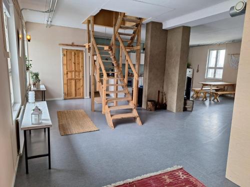 une chambre avec un escalier en colimaçon en bois dans une mezzanine dans l'établissement Charming Studio-Perfect Getaway, à Nummistenkylä