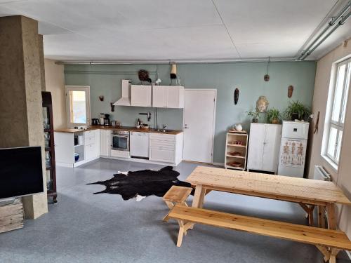 une cuisine avec des placards blancs et une table. dans l'établissement Charming Studio-Perfect Getaway, à Nummistenkylä