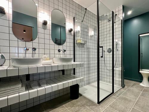 une salle de bain avec deux lavabos et deux miroirs dans l'établissement Un mouton dans l'eglise, à Putot-en-Bessin