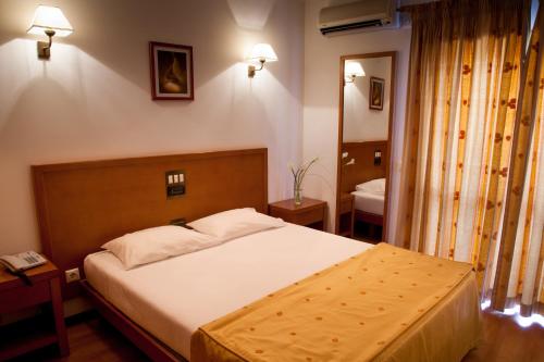 Un dormitorio con una cama grande y un espejo. en Hotel Santa Mafalda, en Fátima