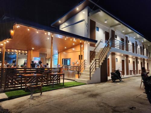 a group of people sitting at a table outside of a building at Malinawon Hotel Room 2 in General Luna