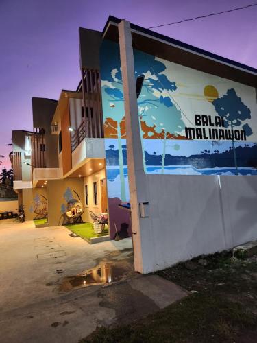 a building with a mural on the side of it at Malinawon Hotel Room 2 in General Luna