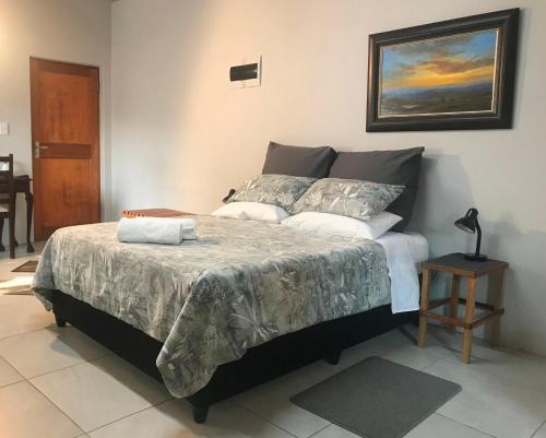 a bedroom with a large bed with a night stand at Kunsvilla in Durbanville