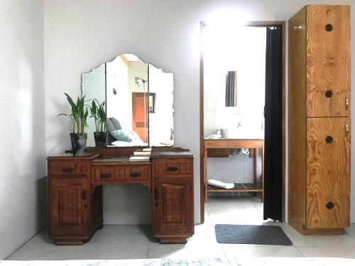 uma casa de banho com um toucador de madeira e um espelho. em Kunsvilla em Durbanville