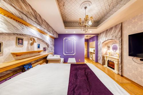 a bedroom with purple walls and a large bed at HOTEL Luna Kawagoe Adult Only in Kawagoe
