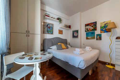 a small bedroom with a bed and a table at Cipro Apartment with balconies in Rome