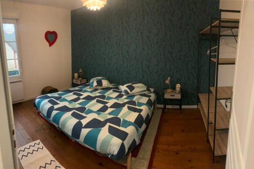 a bedroom with a bed and a green wall at Maison Coeurs de Sologne in Mur-de-Sologne