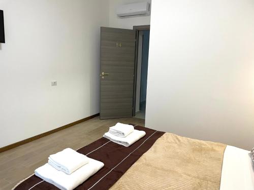 um quarto com duas toalhas sentadas numa cama em FIERA ROOMS em Verona