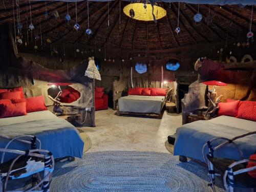 Ngare Nanyuki的住宿－Original Maasai Lodge – Africa Amini Life，一间带两张床的卧室,位于一个天花板的房间