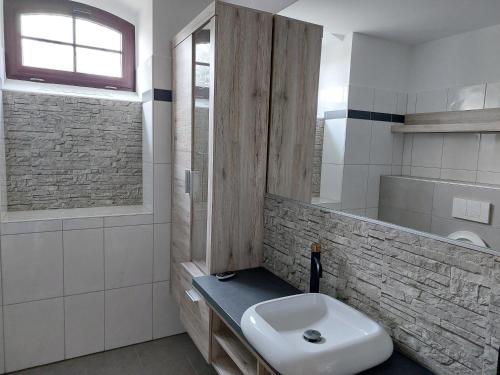 ein weißes Bad mit einem Waschbecken und einem Fenster in der Unterkunft Schlossstrasse in Frankenberg