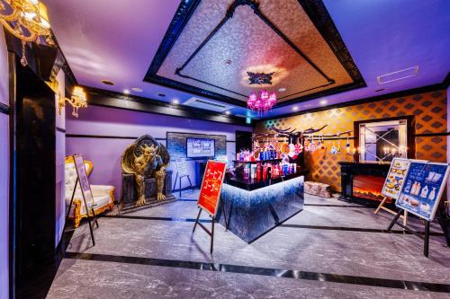a room with a table and chairs and a fireplace at HOTEL Luna Kawagoe Adult Only in Kawagoe