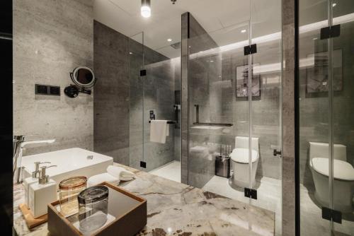 a bathroom with a glass shower and a sink at Radisson Hotel, Beijing DaXing Airport in Beijing