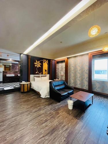 a bedroom with a bed and a couch and a table at Walker Motel in Taipei